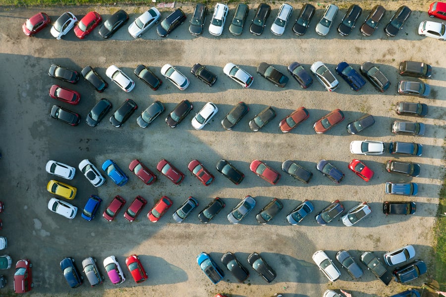 Aerial view of many colorful cars parked on dealer parking l